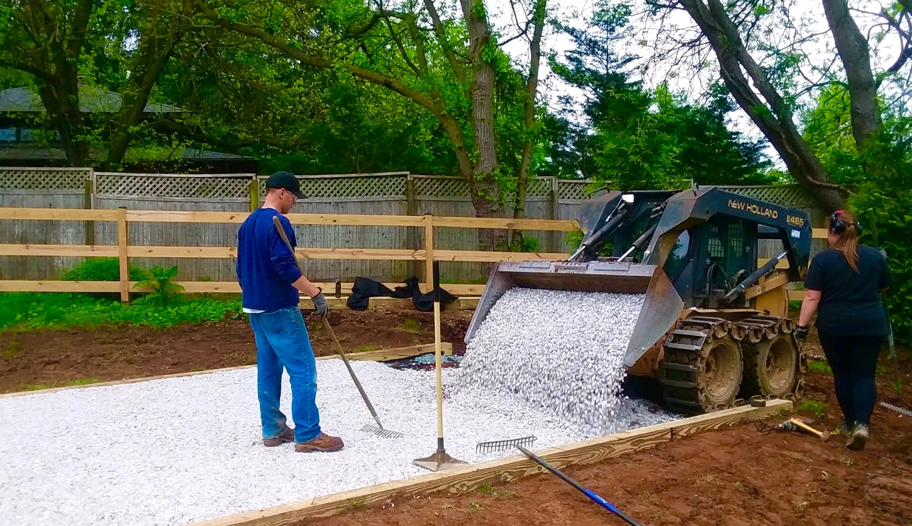 Gravel Pads owners pouring and leveling #57 stone with a skid steer for a shed foundation