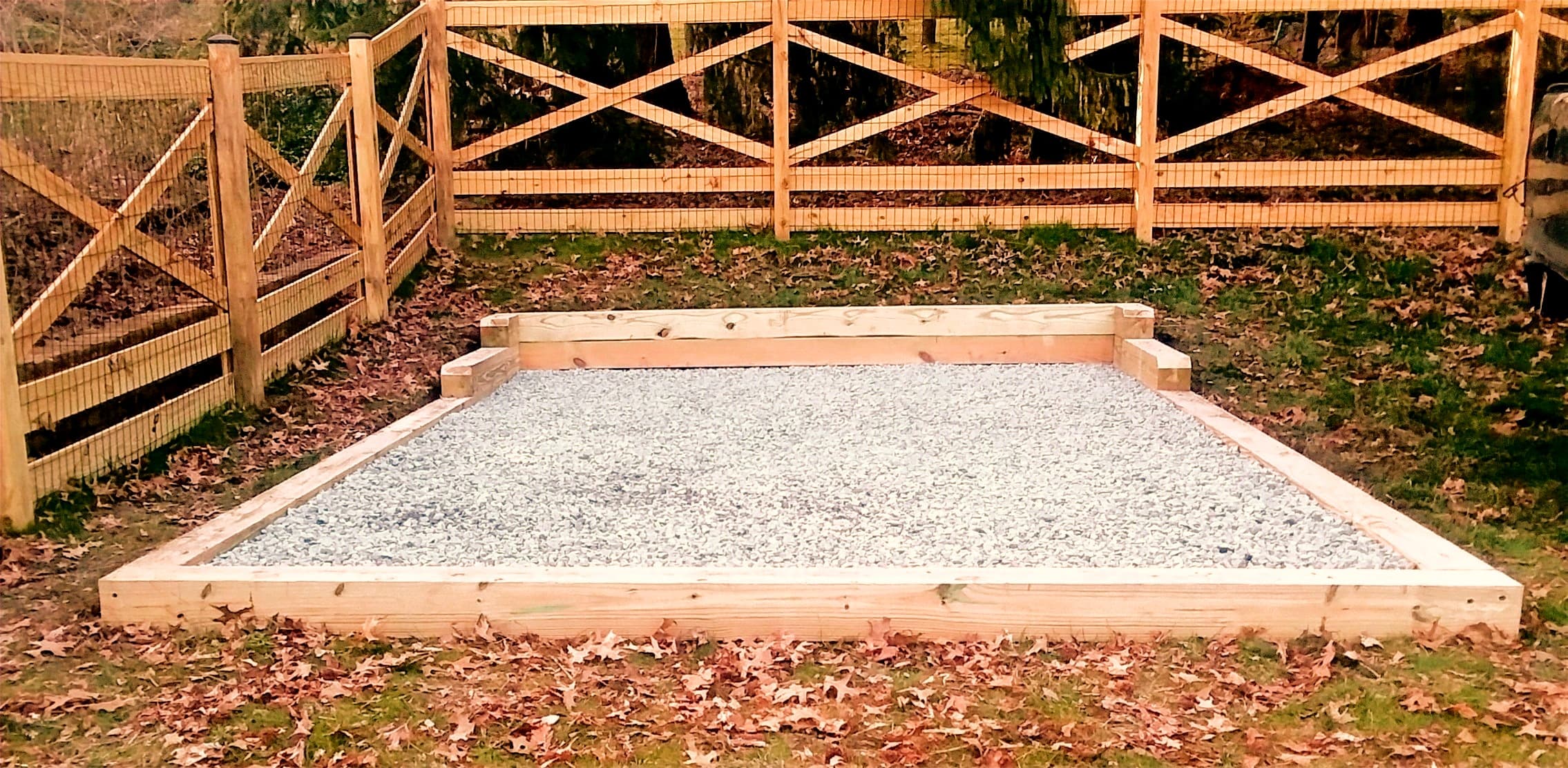A completed gravel pad foundation set level on an open field, ready for shed delivery
